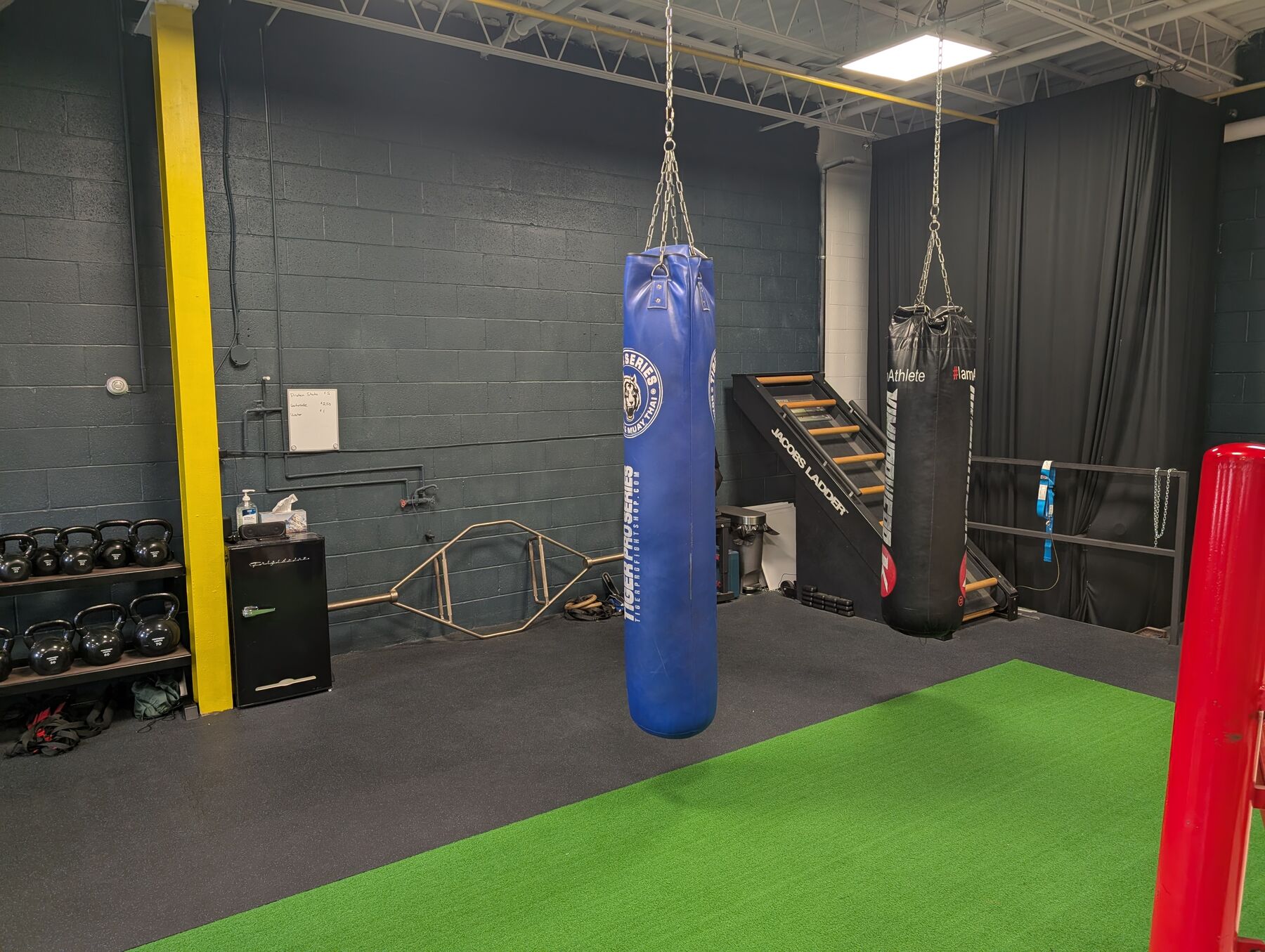 Blue heavy bag hanging on the OBFT training floor